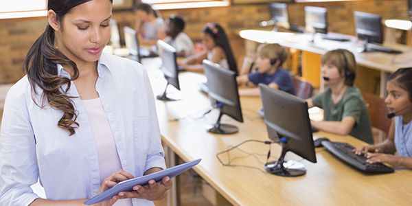 professora usando dispositivo tecnolgico em sala de aula com os alunos