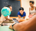 Aluno com smartphone em sala de aula