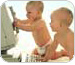 Imagem de dois bebes brincando com as mos em um computador