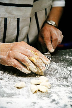 Mãos de um cozinheiro preparando uma massa