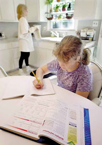 Imagem-de-menina-fazendo-tarefa-na-mesa-da-cozinha