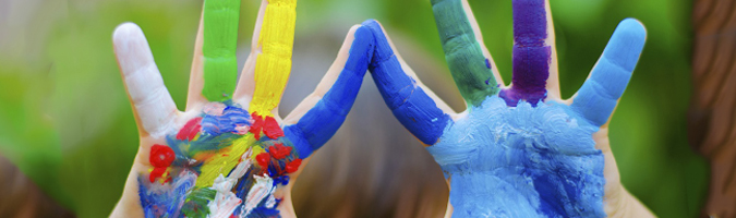 acessibilidade educacional mãos de criança espalmada e cheias de tinta