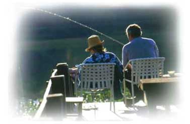 Imagem-de-casal-sentados-pescando-a-beira-de-rio