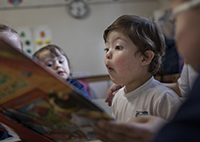 aluno com sindrome de down lendo livro na escola