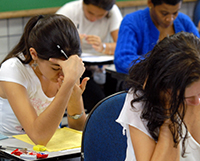 jovens sentados fazendo exame de vestibular